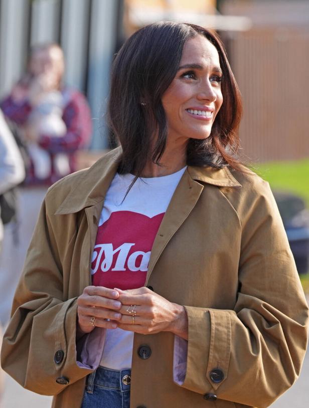 Meghan in einem Trenchcoat mit Jeans und T-Shirt
