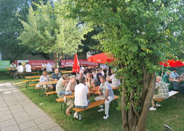 Menschen sitzen auf Bänken zusammen. 