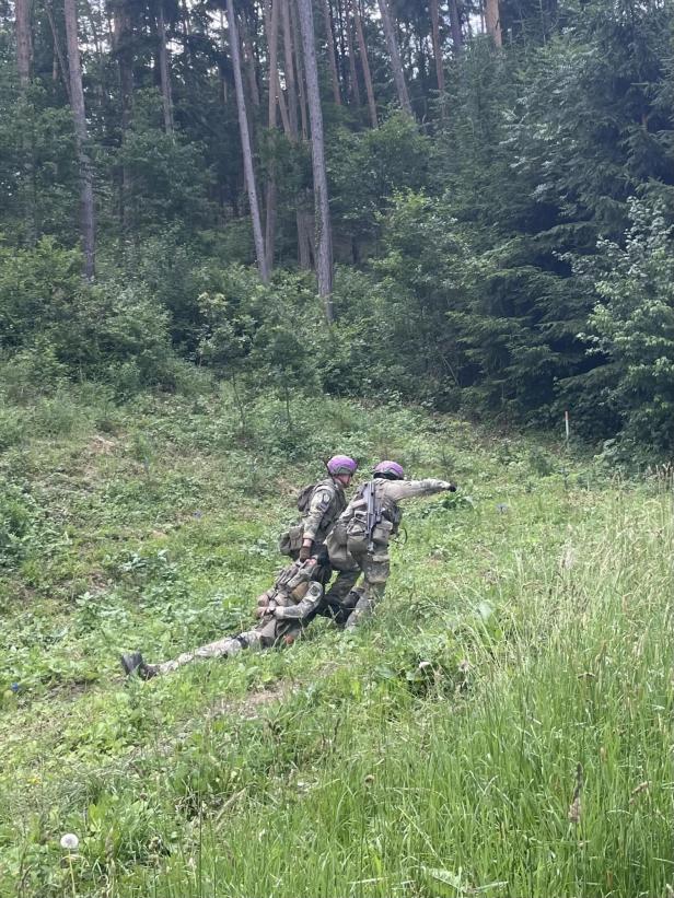 Zwei Soldaten bringen einen "verwundeten" Soldaten in den Wald in Sicherheit
