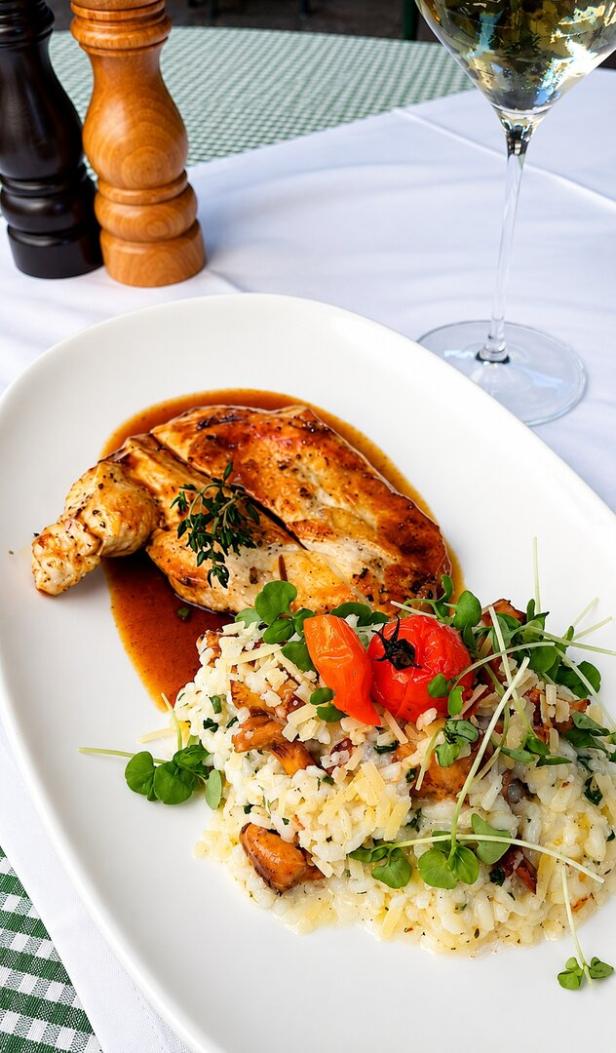 Maishendl und Risotto mit Eierschwammerln serviert beim Pfarrwirt. 