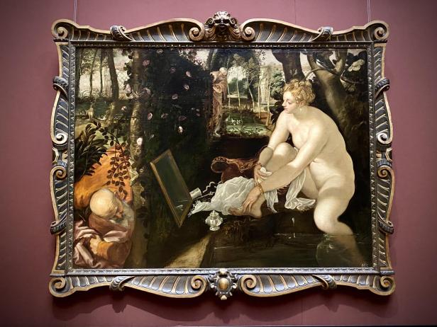 Tintoretto, Susanna im Bade: Eine nackte Frau badet in einem Teich, während sie von zwei versteckten, älteren Männern beobachtet wird, in einem prunkvollen goldenen Rahmen.