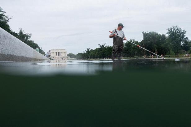 Ein Arbeiter in Wathose reinigt den Reflecting Pool vor dem Lincoln Memorial in Washington, D.C.