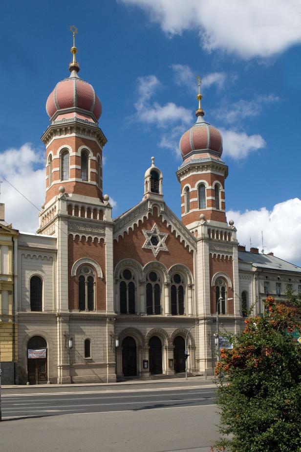 Die Fassade einer Synagoge mit zwei Türmen unter blauem Himmel.