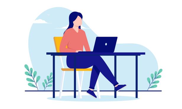 Eine Frau sitzt am Schreibtisch mit Laptop und arbeitet.