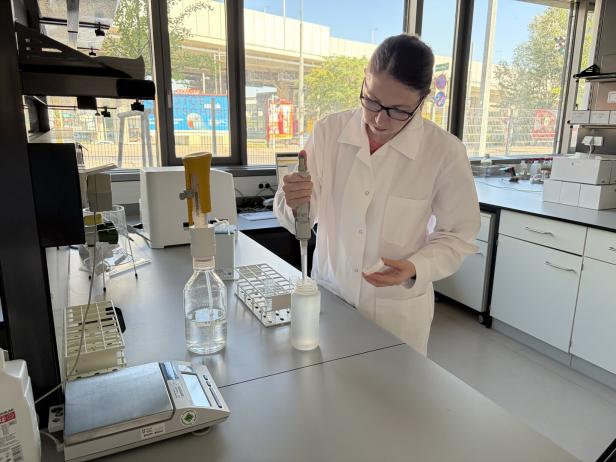 Eine Person untersucht die Wasserprobe im Labor.