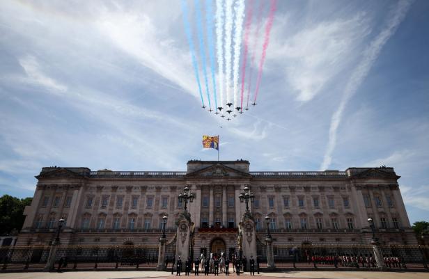 Kampfjets fliegen in Formation über den Buckingham Palace, darunter die britische Flagge.