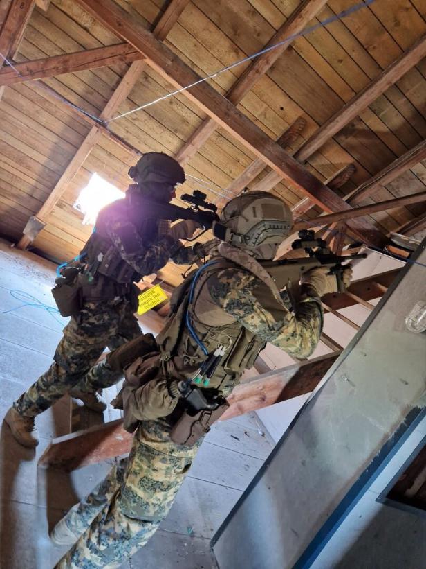 Soldaten beim Durchsuchen eines Dachbodens.