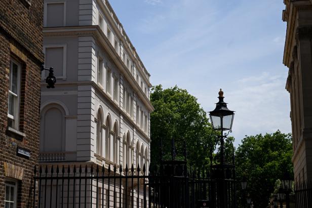 Clarence House in London hinter einem schwarzen Metallzaun mit einer verzierten Straßenlaterne.