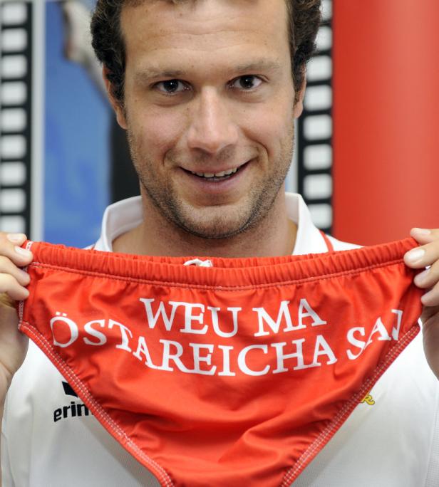 Ein Mann hält eine rote Unterhose mit der Aufschrift „Österreicha Weu Ma San“ hoch.