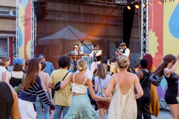 Frauen tanzen zur Musik, die live auf der Bühne gespielt wird