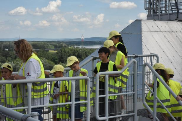 Kinder in Warnwesten besichtigen die Aussicht vom Kraftwerksdach der EVN