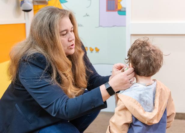 Heidi Neuroth passt Josi die Hörgeräte an. 