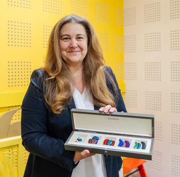Heidi Neuroth hält unterschiedliche Hörgeräte in der Hand.