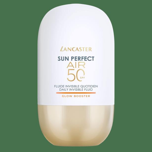 Weiße und goldene Lancaster Sun Perfect Air SPF 50 Sonnenpflegeflasche auf grünem Hintergrund.