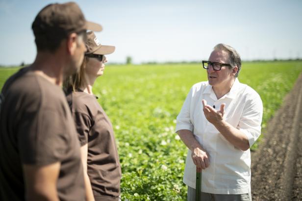 Robert Palfrader spricht mit Sabine und Thomas Andert auf einem Gemüsefeld im Seewinkel.