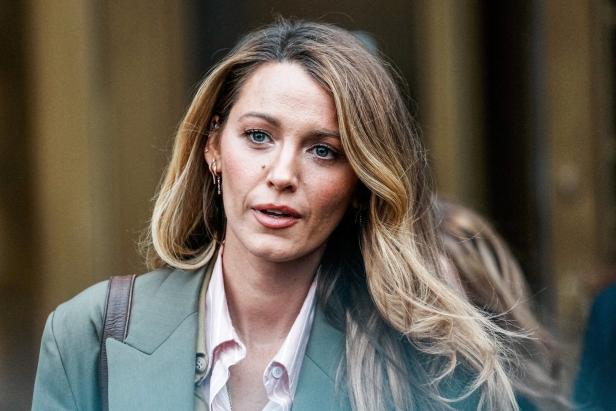 Blake Lively mit blondem Haar trägt ein helles Hemd unter einem olivgrünen Blazer.