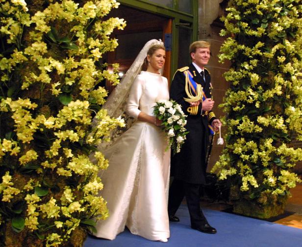 Dutch Crown Prince Willem-Alexander (R) escorts his bride Maxima Zorreguieta through a flower-decora..