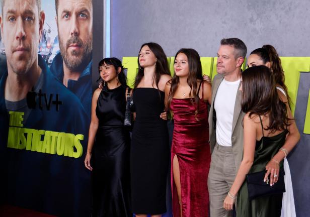 Matt Damon posiert mit seiner Familie und Gästen vor einem Plakat für den Film „The Instigators“.