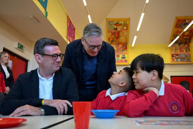 Britain's Prime Minister Keir Starmer meets school children at a breakfast club with Greater Manchester Mayor Andy Burnham, during a visit to a primary school