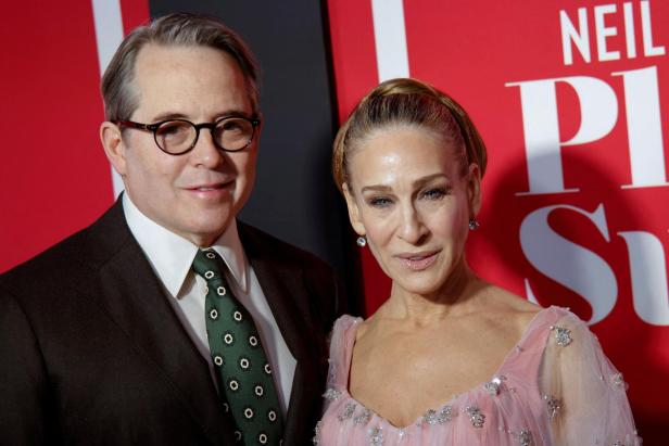 Matthew Broderick und Sarah Jessica Parker in Abendkleidung posieren gemeinsam vor einem roten Hintergrund.