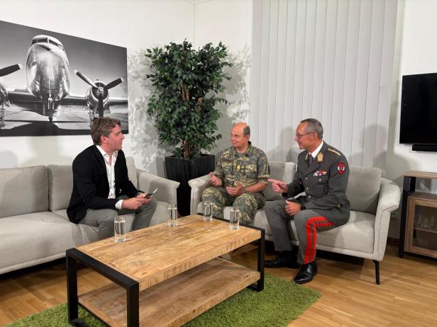 Drei Männer sitzen zum Interview auf Sofas in einem hellen Raum.