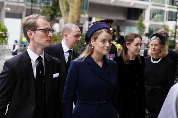 Flora Vesterberg in formeller, dunkler Kleidung gehen bei einer offiziellen Veranstaltung nebeneinander her.