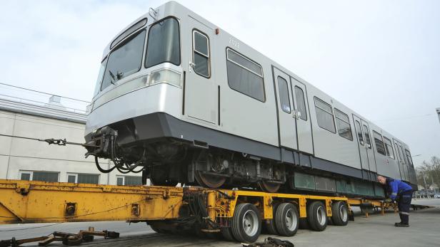 Ein U-Bahn-Waggon wird auf einem gelben Tieflader transportiert.