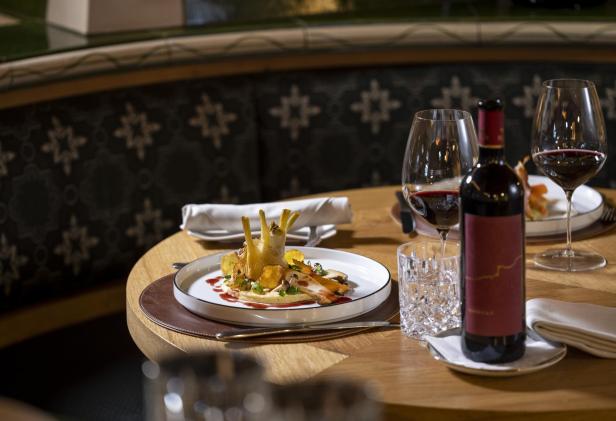 Fein angerichtetes Menü mit Rotwein auf einem Restauranttisch.
