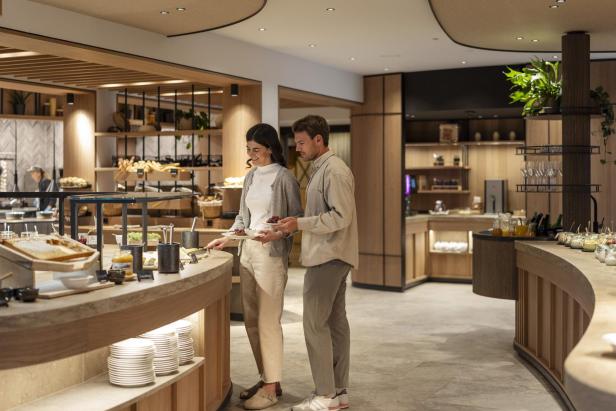 Paar nimmt Speisen an einem modernen Buffet im Hotelrestaurant.