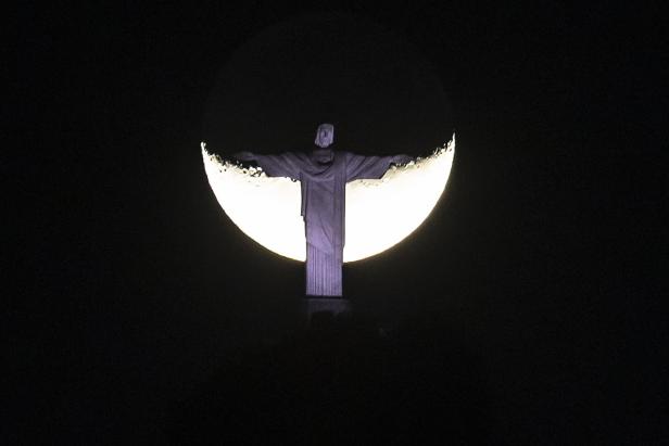Moon rises behind Christ the Redeemer statue in Rio de Janeiro