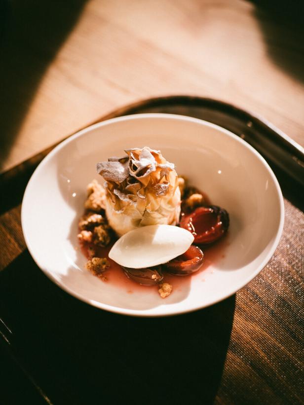Dessertschale mit feinem Gebäck, Kirschen und einer Kugel Eis.