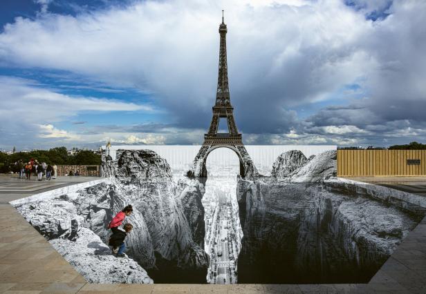 Eiffelturm über einer optischen Illusion mit scheinbarem Abgrund und zwei Kindern am Rand.