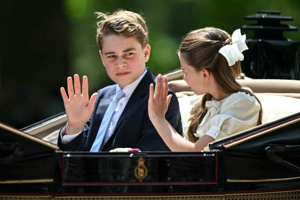 Prinz George und Prinzessin Charlotte winken aus einer Kutsche heraus.