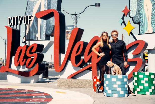 Ein Paar posiert mit seinem kleinen Hund vor dem „City of Las Vegas“-Schild.