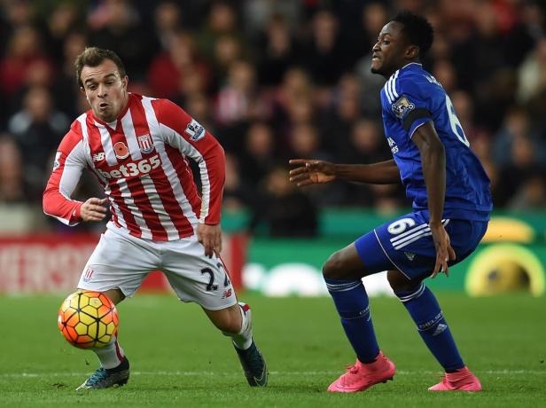 Zwei Fußballspieler kämpfen um den Ball auf dem Spielfeld.