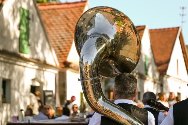 Musikant mit Sousaphon bei einem Weinfest in einer Kellergasse.