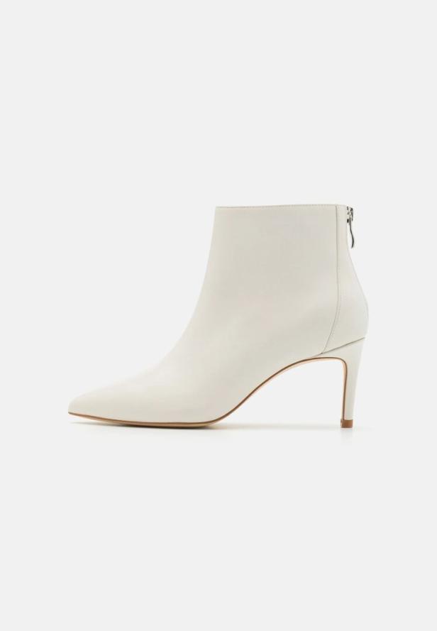 Weiße Stiefelette mit spitzer Form und schmalem Absatz auf weißem Hintergrund.