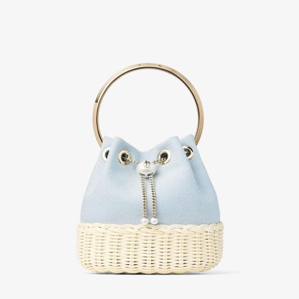 Hellblaue Beuteltasche mit goldfarbenem Rundgriff und cremefarbenem Flechtboden.
