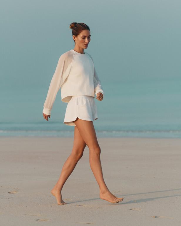 Für den Strand. Ein simples Sweatshirt, eine kurze Short, cremiges Weiß. Mit seinem reduzierten Zweiteiler zeigt Eres, dass entspannter Chic am Strand keine Extras braucht.