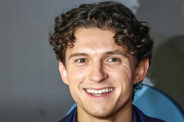 Tom Holland lächelt freundlich in die Kamera.