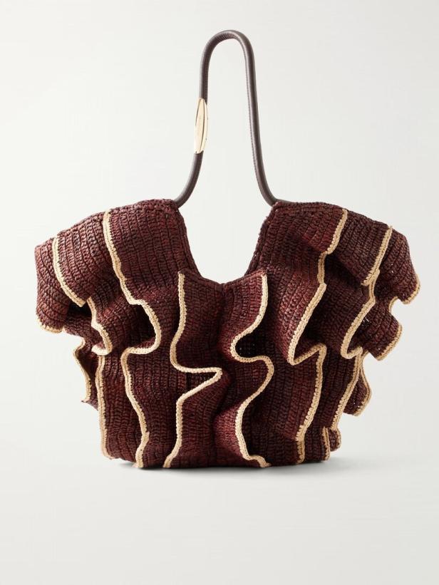 Bordeauxfarbene, strukturierte Handtasche mit geschwungenem Griff und welligen hellen Zierkanten.