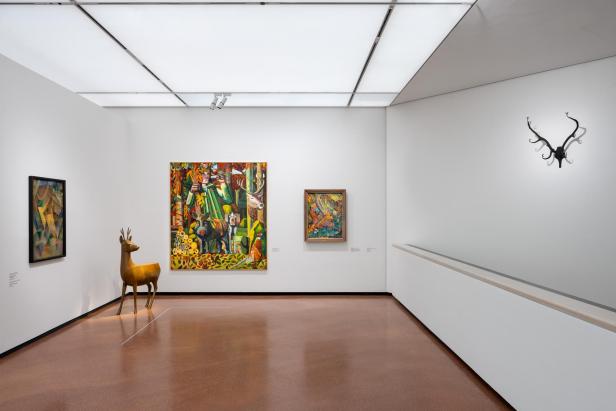 Ausstellungsraum mit Tierkunstwerken, darunter ein goldenes Hirschobjekt und ein Geweih an der Wand.