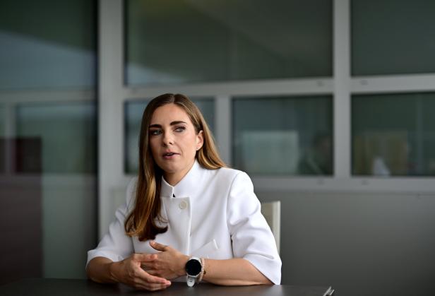 Simone Stribl in weißer Jacke an einem Tisch sitzend.