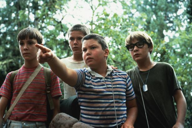 Vier Jungen stehen im Wald, wobei einer von ihnen in die Ferne zeigt, eine Szene aus dem Film Stand by Me.