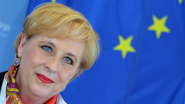 Eine Frau mit blonden Haaren vor der Europaflagge.