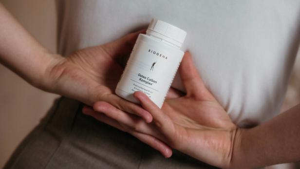 Frau hält BIOGENA Osteo Calbon Komplex Gold Dose in der Hand.