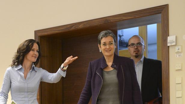 Drei Personen stehen in einem Türrahmen.