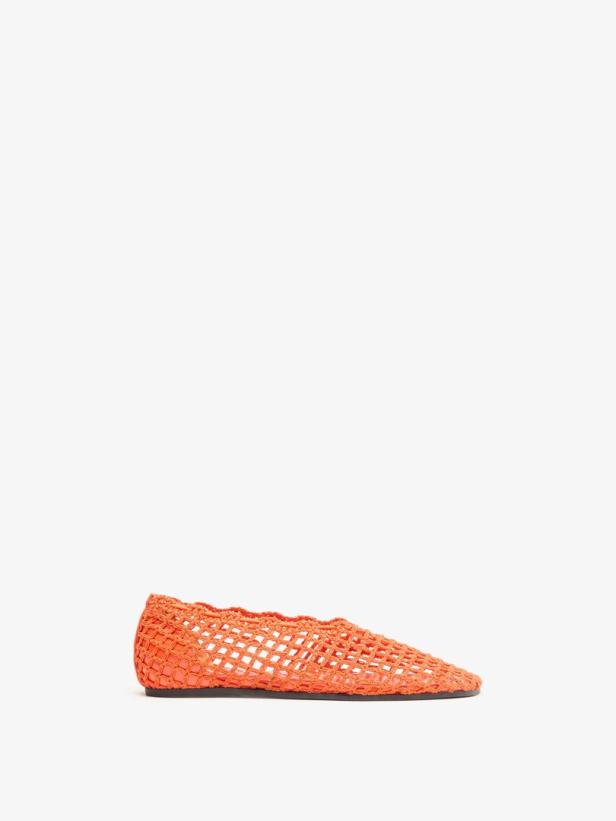 Ein orangefarbener, flacher Schuh mit einem geflochtenen Netzmuster vor weißem Hintergrund.