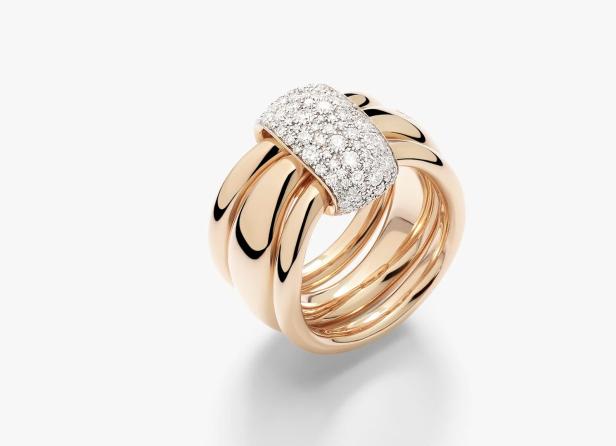 Ein breiter Ring aus Roségold mit drei ineinander verschlungenen Bändern, die oben mit einem mit Diamanten besetzten Element verbunden sind.