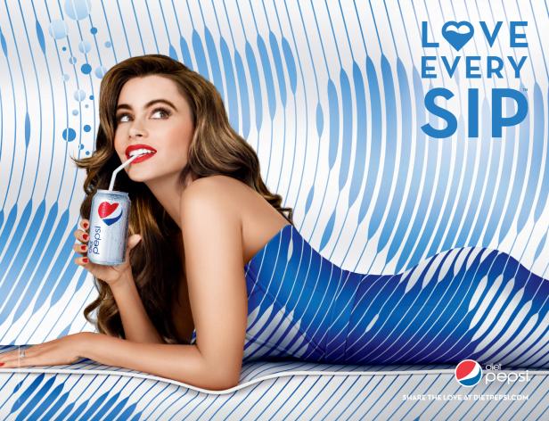 Sofia Vergara liegt auf einer blau-weiß gestreiften Oberfläche und trinkt Diät-Pepsi.